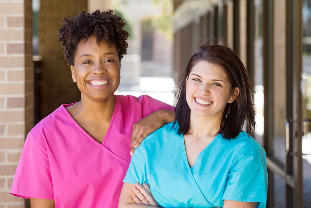 Two care staff members smiling